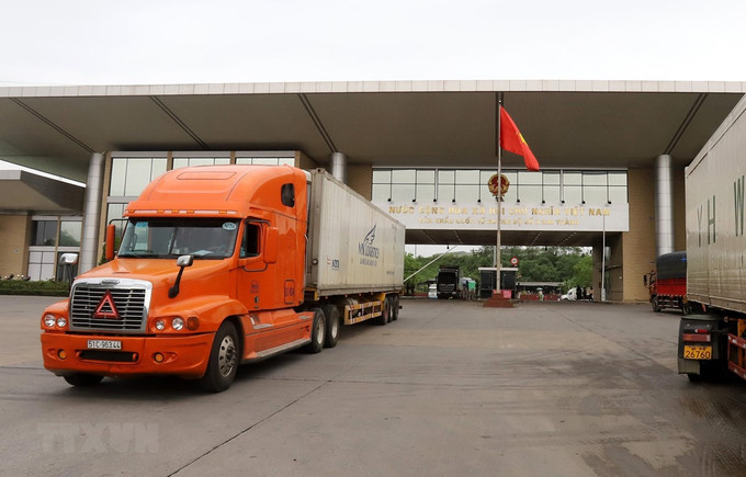 Các xe container chở quả vải thiều được xuất khẩu sang thị trường Trung Quốc tại Cửa khẩu Quốc tế đường bộ số 2 Kim Thành. Ảnh: Quốc Khánh/TTXVN Lào Cai xây dựng Trung tâm xúc tiến thương mại và chợ biên giới Kim Thành ảnh 1