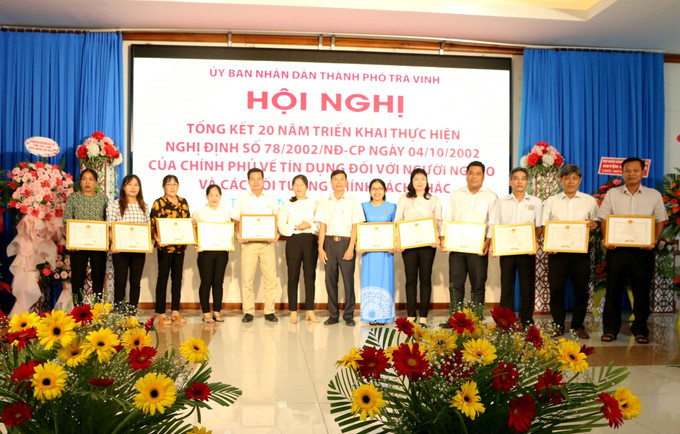 Trao Bằng khen của UBND thành phố Trà Vinh cho các tập thể và cá nhân có thành tích xuất sắc. Ảnh: Thanh Hòa - TTXVN Trà Vinh xây dựng và nhân rộng các mô hình, dự án giảm nghèo ảnh 1