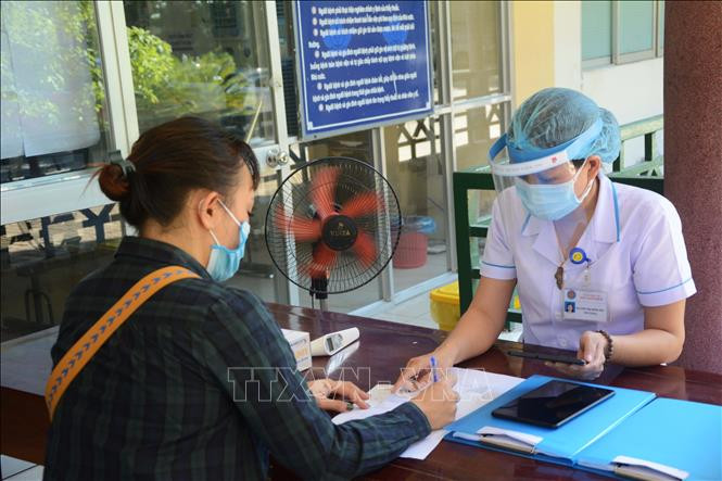 Nhân viên y tế kiểm tra lịch sử dịch tễ của bệnh nhân khi vào khám bệnh. Ảnh: Văn Dũng - TTXVN Bộ Y tế hướng dẫn kê đơn thuốc trong thời gian phòng, chống dịch COVID-19 ảnh 1