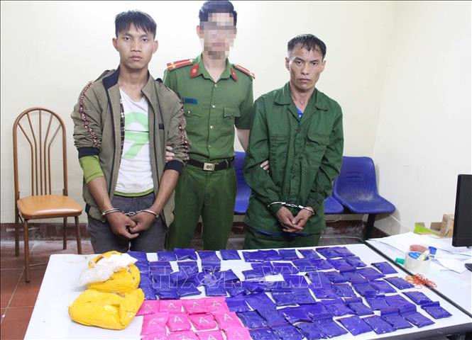 Hai đối tượng và tang vật tại cơ quan Công an. Ảnh: TTXVN phát Sơn La bắt quả tang hai đối tượng mua bán hơn 15.000 viên ma túy tổng hợp ảnh 1