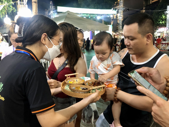 Du khách háo hức thử các món ăn tại “Tuần hàng Quảng bá nông sản, sản phẩm OCOP Hà Nội và các tỉnh, thành phố năm 2022”. Ảnh: Phương Anh - TTXVN Khai mạc “Tuần hàng quảng bá nông sản, sản phẩm OCOP Hà Nội và các tỉnh, thành phố năm 2022” ảnh 3