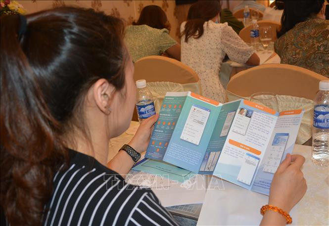 Người dân xem hướng dẫn cài đặt ứng dụng Bảo hiểm xã hội số (VssID). Ảnh: Văn Dũng – TTXVN Bảo hiểm xã hội Việt Nam đẩy mạnh cải cách hành chính, tăng cường trách nhiệm người đứng đầu ảnh 2