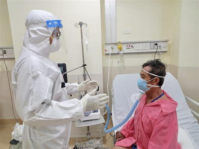 Cán bộ y tế chăm sóc người bệnh F0. Ảnh: TTXVN phát Chuyển COVID-19 sang “bệnh nhóm B” – Nhiều câu hỏi bỏ ngỏ ảnh 4