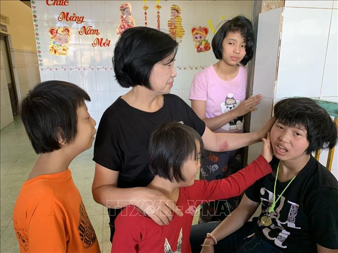 Bà Phạm Thị Hồng bên những đứa con đặc biệt của mình. Ảnh: Quang Thái - TTXVN Phạm Thị Hồng - Người mẹ nâng bước những mảnh đời bất hạnh ảnh 4