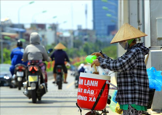 Một người bán hàng rong dưới trời nắng nóng trên 40 độ C. Ảnh: An Đăng - TTXVN Nhiều thành phố có chỉ số tia cực tím gây hại rất cao ảnh 1