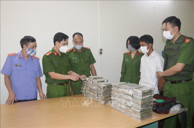 Thượng tá Nguyễn Ngọc Thắng (thứ 2 từ trái sang phải), Phó Giám đốc Công an tỉnh Điện Biên đang kiểm tra tang vật vụ án trong chuyên án 121V. Ảnh: TTXVN phát Bắt hai đối tượng Vàng A Súa và Sùng A Hòa vận chuyển ma túy trái phép ảnh 1