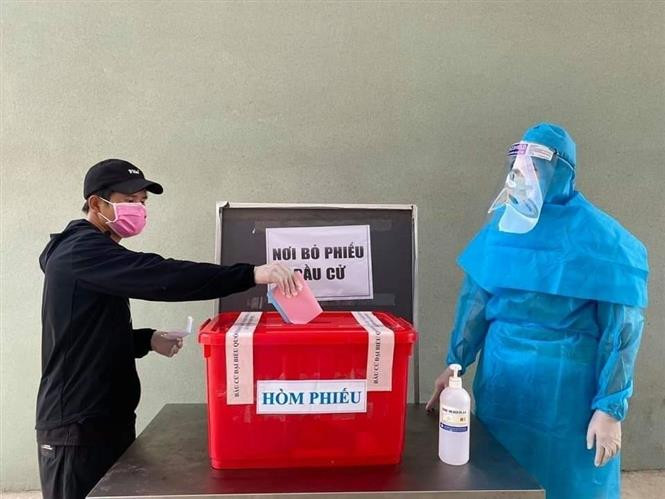 Cử tri tại khu cách ly tập trung ở huyện Bàu Bàng, tỉnh Bình Dương được thực hiện quyền nghĩa vụ của mình trong ngày đi bầu cử. Ảnh: TTXVN phát Bầu cử QH và HĐND: Dân chủ, bình đẳng, đúng pháp luật, tuyệt đối an toàn và thành công rất tốt đẹp (Bài 1) ảnh 4
