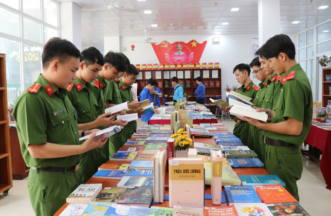 Các chiến sĩ Công an đọc các ấn phẩm trưng bày tại Chương trình. Ảnh: Nguyễn Thành – TTXVN Ninh Thuận phát triển văn hóa đọc sâu rộng trong cộng đồng ảnh 3