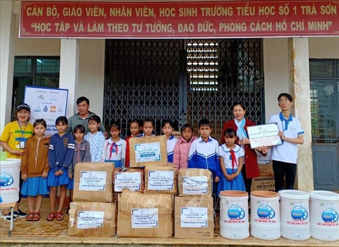 Các tình nguyện viên Nhóm Fly to Sky trao quà cho các trường học trên địa bàn tỉnh Quảng Ngãi. Ảnh: Lê Ngọc Phước-TTXVN Tiếp sức học sinh vùng chịu ảnh hưởng của bão, lũ đến trường ảnh 1