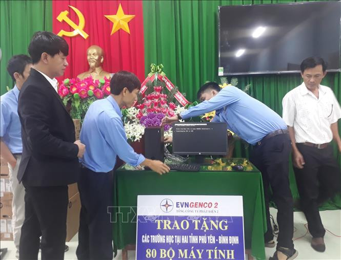 Các nhân viên Điện lực Bình Định lắp đặt máy tính cho các trường học được Tổng công ty Phát điện 2 trao tặng. Ảnh: Tường Quân - TTXVN Trao tặng máy vi tính cho các trường học khó khăn tại Bình Định và Phú Yên ảnh 2
