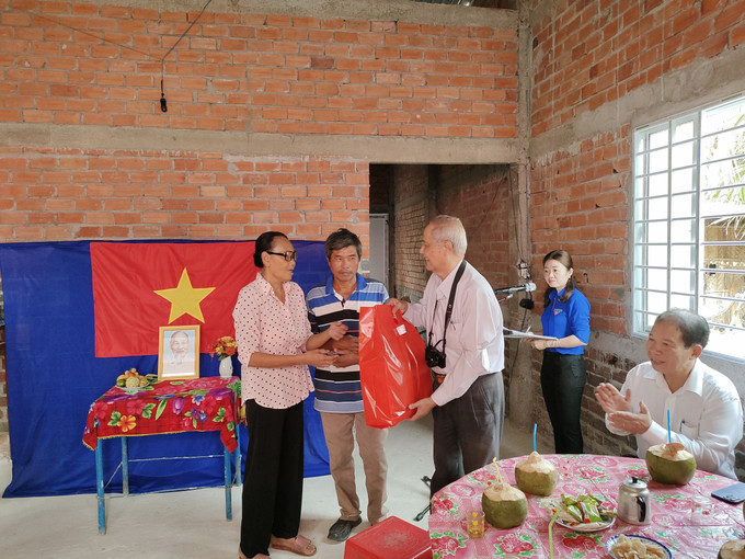 Trao quà, thăm hỏi người dân nhận nhà mới. Ảnh: Huỳnh Phúc Hậu - TTXVN Bến Tre: Bàn giao 60 căn nhà tình nghĩa, tình thương, đại đoàn kết ảnh 3