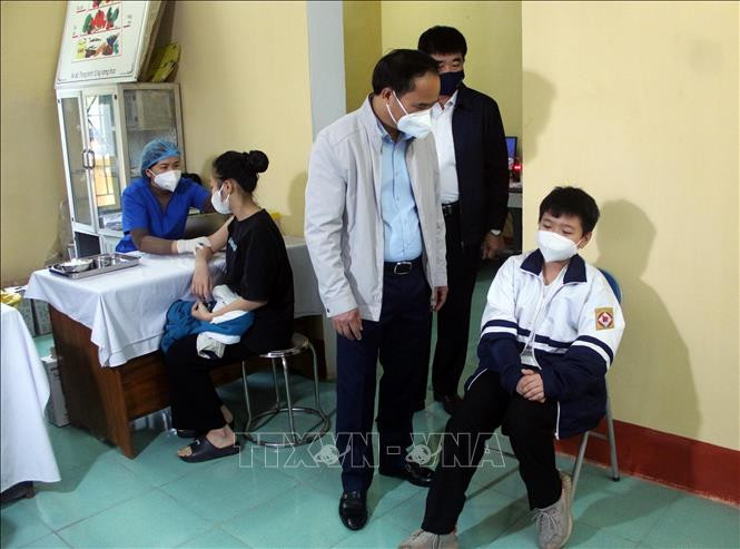 Kiểm tra công tác tiêm vaccine phòng COVID-19 cho học sinh tại Trạm Y tế . Ảnh: Quang Cường – TTXVN Cách phân biệt bệnh dị ứng thời tiết theo mùa và COVID-19 ảnh 1