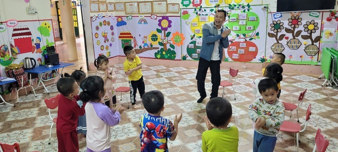 Thầy giáo Trịnh Hồng Quân, Trường Mầm non Thành Sơn (Bá Thước, Thanh Hóa), trong một tiết dạy múa, hát cho trẻ. Ảnh: TTXVN phát Chuyện về những "thầy nuôi dạy trẻ" ở huyện vùng cao Như Xuân ảnh 1