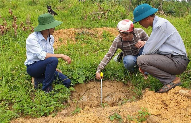 Cán bộ nông nghiệp xã Nậm Manh, huyện Nậm Nhùn (Lai Châu) hướng dẫn bà con dân tộc trên địa bàn đào hố trồng cây xoài Đài Loan đúng kỹ thuật. Ảnh: Việt Hoàng - TTXVN Nỗ lực giảm nghèo ở huyện vùng cao biên giới Nậm Nhùn ảnh 1
