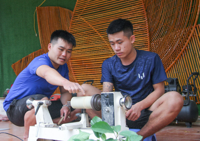 Anh Hoàng Ngọc Hồi (bên trái) hướng dẫn thanh niên làm sản phẩm đồ mỹ nghệ từ tre trúc. Ảnh: Nam Thái – TTXVN Tuổi trẻ Hoàng Su Phì lập nghiệp trên mảnh đất quê hương ảnh 2