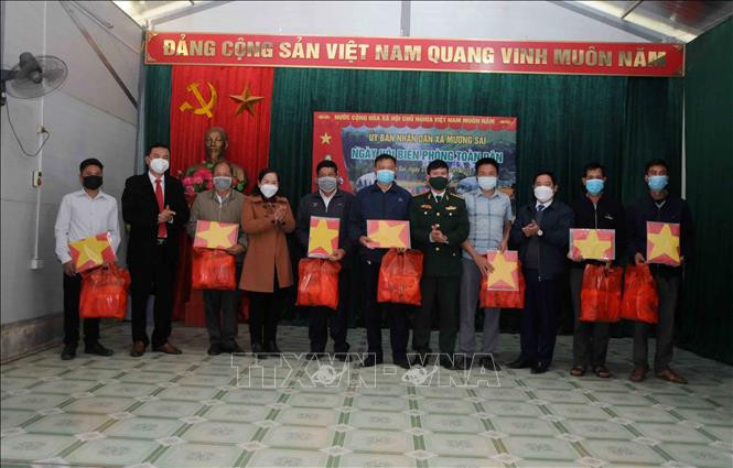 Ban tổ chức tặng quà và cờ Tổ quốc cho các già làng, trưởng bản, người có uy tín xã Mường Sai, huyện Sông Mã, tỉnh Sơn La. Ảnh: Quang Quyết-TTXVN Đồn Biên phòng Cửa khẩu Chiềng Khương tổ chức Ngày hội Biên phòng toàn dân năm 2022 ảnh 1
