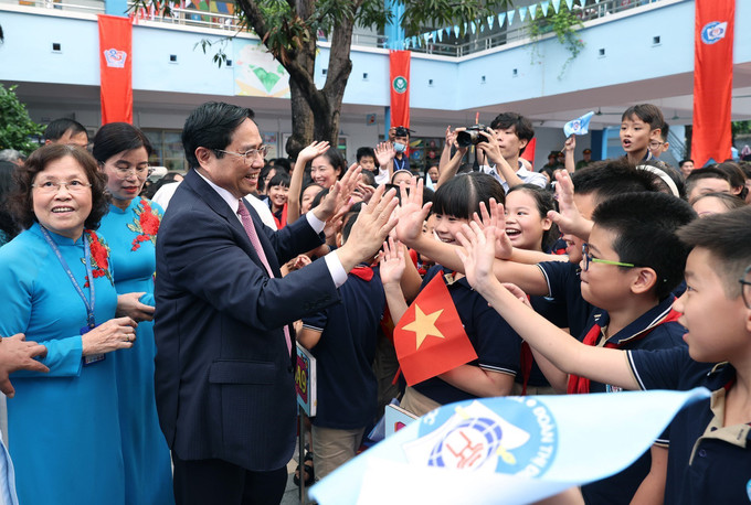 Thủ tướng Phạm Minh Chính với học sinh Trường Tiểu học Đoàn Thị Điểm. Ảnh: Dương Giang-TTXVN Thủ tướng Phạm Minh Chính: Thực hiện 3 cân bằng “học - chơi - ăn ngủ” cho học sinh ảnh 4