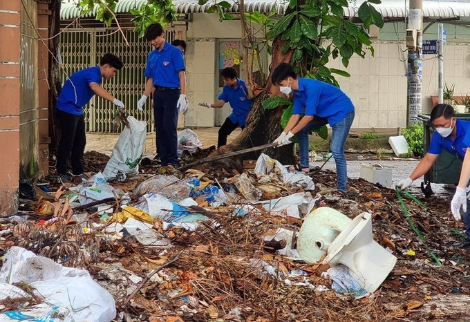 Đoàn viên, thanh niên thu gom rác thải. Ảnh: TTXVN phát Kiên Giang ra quân "Ngày Chủ Nhật xanh" lần II/2023 ảnh 2