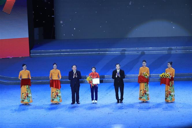 Ông Nguyễn Văn Hùng, Bộ trưởng Bộ VH, TT và DL, Chủ tịch Liên đoàn thể thao Đông Nam Á, Chủ tịch Ủy ban Olympic Việt Nam, Trưởng Ban tổ chức SEA Games 31 và ông Chu Ngọc Anh, Chủ tịch UBND TP Hà Nội trao trao Bằng vinh danh VĐV Nguyễn Thị Oanh (Việt Nam, 3 HCV). Ảnh: TTXVN Lễ Bế mạc SEA Games 31: Hội tụ để cùng ngân vang khúc ca chiến thắng ảnh 4