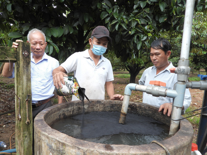 Ông Nguyễn Hữu Năm (trái) cùng các xã viên pha thuốc sinh học để chuẩn bị phun tưới bằng máy đa năng. Ảnh: K GỬIH-TTXVN "Ông Năm sầu riêng” với sáng tạo khoa học kỹ thuật, sản xuất nông nghiệp hữu cơ ảnh 3