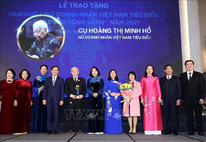 Phó Chủ tịch nước Võ Thị Ánh Xuân và Trưởng Ban Dân vận Trung ương Bùi Thị Minh Hoài trao Cúp và hoa cho đại diện gia đình cụ Hoàng Thị Minh Hồ. Ảnh: Trọng Đức - TTXVN Phó Chủ tịch nước Võ Thị Ánh Xuân trao tặng danh hiệu Nữ doanh nhân Việt Nam tiêu biểu năm 2021 ảnh 1