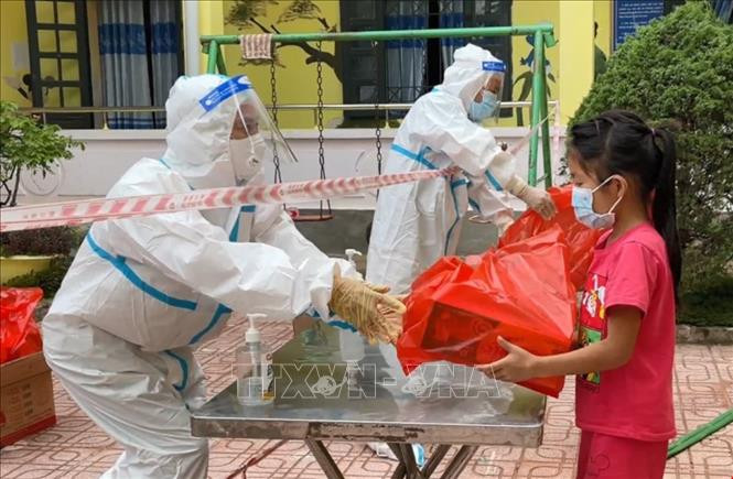Lực lượng y tế, các thầy cô trao quà Tết Thiếu nhi cho các cháu đang thực hiện cách ly tại Khu cách ly tập trung Trường Phổ thông dân tộc bán trú Tiểu học xã Phìn Hồ (xã Phìn Hồ, huyện Nậm Pồ, tỉnh Điện Biên). Ảnh: Xuân Tiến - TTXVN Tết Thiếu nhi ấm áp trong “tâm dịch” Nậm Pồ ảnh 1