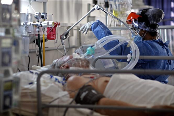 Điều trị cho bệnh nhân nhiễm COVID-19 tại bệnh viện ở Cordoba, Argentina. Ảnh: AFP/TTXVN COVID-19: Từ đại dịch tới “bệnh đặc hữu” (Bài 1) ảnh 2