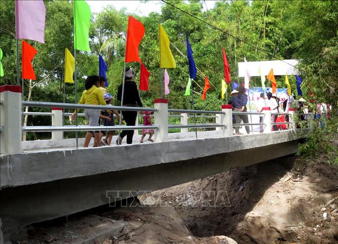 Người dân phấn khởi khi được đi trên cây cầu mới khang trang. Ảnh: Phước Ngọc- TTXVN Quảng Ngãi: Đưa vào sử dụng cây cầu tại vùng thường xuyên bị cô lập do mưa lũ ảnh 2
