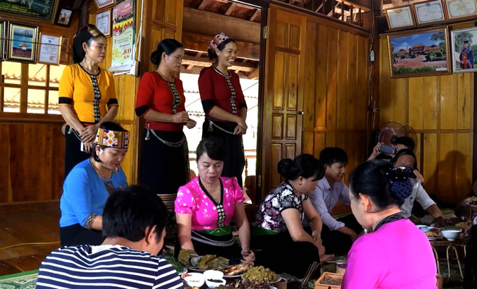 Du khách trải nghiệm ẩm thực đậm nét văn hoá của dân tộc Thái tại huyện Con Cuông, tỉnh Nghệ An. Ảnh: Văn Tý-TTXVN Nghệ An tháo gỡ điểm nghẽn để phát triển du lịch ảnh 1
