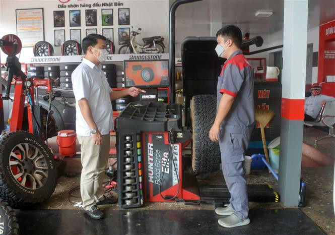 Anh Vinh (trái) hướng dẫn nhân viên cải tiến quy trình để thích ứng với tình hình dịch và làm hài lòng khách hàng. Ảnh: Hoài Thu – TTXVN Doanh nhân Nguyễn Quang Vinh giữ chữ tín để thành công ảnh 3