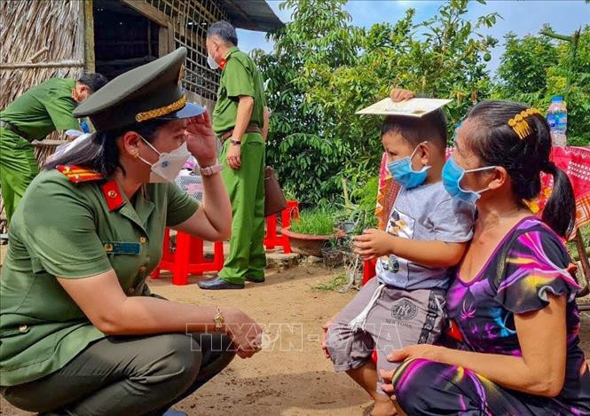 Nữ cán bộ Công an TP Cần Thơ trò chuyện với bé Nguyễn Huỳnh Gia Bảo (xã Tân Thới, huyện Phong Điền) có cha mất do COVID-19. Ảnh: Thanh Liêm - TTXVN Đề xuất chính sách hỗ trợ trẻ mồ côi do dịch COVID-19 ảnh 1