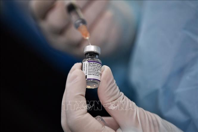 Nhân viên y tế chuẩn bị mũi tiêm vaccine ngừa COVID-19 của hãng Pfizer/BioNTech tại một điểm tiêm chủng ở Bangkok, Thái Lan ngày 4/10/2021. Ảnh: AFP/TTXVN Mũi vaccine ngừa COVID-19 tăng cường của Pfizer/BioNTech cải thiện phản ứng miễn dịch ở bệnh nhân ung thư xạ trị ảnh 1