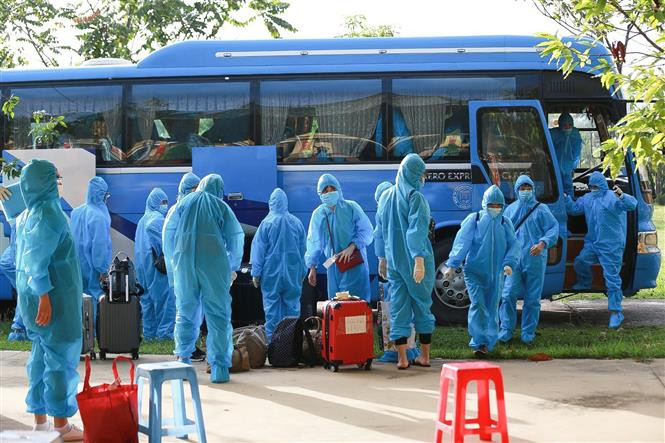 Các công dân trong bộ đồ bảo hộ xuống xe vào khu cách ly bắt đầu thực hiện các quy định theo dõi COVID-19. Ảnh: Trọng Đạt - TTXVN Hòa Bình tiếp nhận 91 công dân từ Đài Loan (Trung Quốc) về cách ly tại Trung đoàn 814 ảnh 3