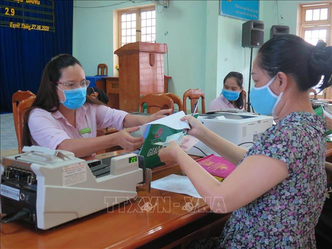 Người dân phường Quyết Thắng, thành phố Kon Tum làm thủ tục nhận tiền vay vốn tín dụng chính sách. Ảnh: Dư Toán – TTXVN Vốn tín dụng chính sách góp phần giảm nghèo ở Kon Tum ảnh 1