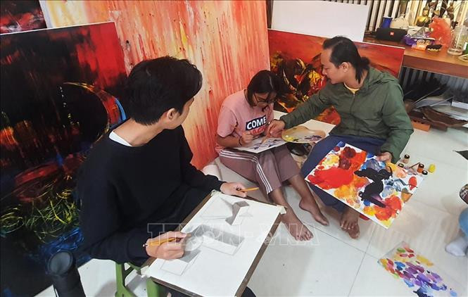 Họa sĩ Ngô Thanh Hùng dạy học sinh vẽ tại nhà. Ảnh: Văn Dũng - TTXVN Họa sĩ Ngô Thanh Hùng - Người thổi hồn vào tranh vẽ trâu ảnh 1