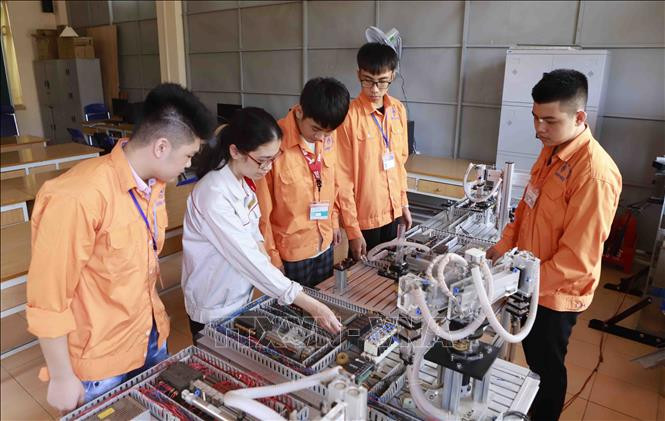 Cô giáo và học sinh Khoa điện tử Trường Cao đẳng nghề Vĩnh Phúc trong giờ học thực hành. Ảnh: Hoàng Hùng - TTXVN Hướng dẫn tuyển sinh, tổ chức đào tạo giáo dục nghề nghiệp trong bối cảnh dịch COVID-19 kéo dài ảnh 1