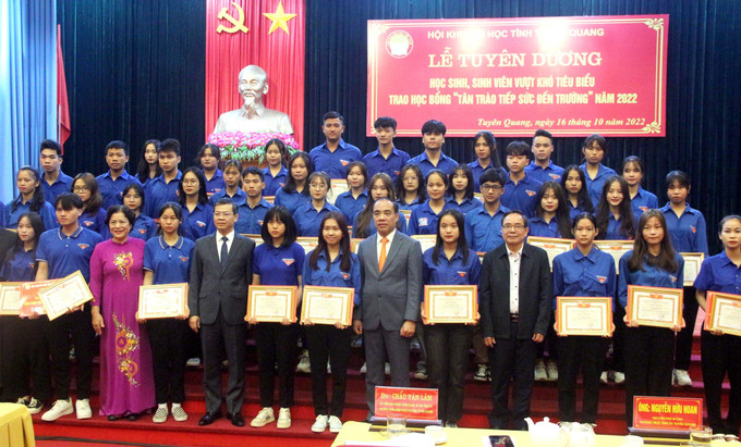 Các sinh viên vượt khó tiêu biểu chụp ảnh lưu niệm cùng các lãnh đạo tỉnh Tuyên Quang. Ảnh: Quang Cường - TTXVN Góp phần động viên học sinh, sinh viên nghèo vượt khó yên tâm, tự tin học tập ảnh 1