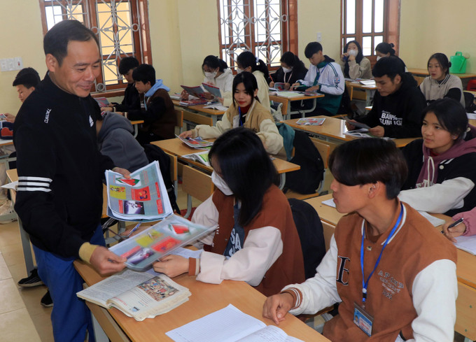 Cán bộ Trung tâm Y tế phát tờ rơi tuyên truyền về sức khỏe sinh sản cho học sinh. Ảnh: Hữu Quyết – TTXVN Triển khai đồng bộ các giải pháp, đẩy lùi vấn nạn tảo hôn ảnh 1