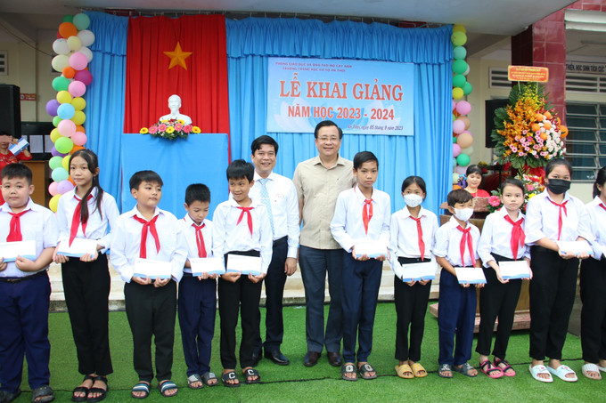 Quỹ phát triển Đại học Quốc gia thành phố Hồ Chí Minh trao quà cho các học sinh vượt khó trường Trung học cơ sở An Thới, huyện Mỏ Cày Nam, tỉnh Bến Tre. Ảnh: Chương Đài - TTXVN Bộ trưởng Huỳnh Thành Đạt trao học bổng cho học sinh vượt khó tỉnh Bến Tre ảnh 1