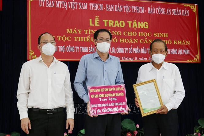 Ông Nguyễn Hồ Hải, Phó Bí thư Thành ủy Thành phố Hồ Chí Minh (ngoài cùng bên trái), ông Nguyễn Thành Trung, Phó Chủ tịch Ủy ban MTTQ Việt Nam Thành phố (giữa) tiếp nhận tượng trưng số máy tính do Quỹ Bảo trợ học sinh dân tộc thiểu, học sinh nghèo Báo Công an Nhân dân tặng; ông Trương Hòa Bình, nguyên Ủy viên Bộ Chính trị, nguyên Phó Thủ tướng Thường trực Chính phủ tiếp nhận thư cảm ơn của Thành phố. Ảnh: Xuân Khu-TTXVN Trao tặng máy tính hỗ trợ học sinh dân tộc Chăm, Khmer ở Thành phố Hồ Chí Minh học trực tuyến ảnh 4