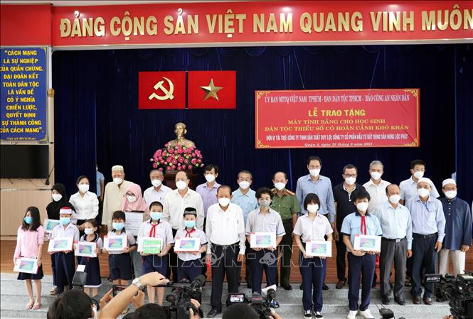 Trao tặng máy tính bảng cho các em học sinh. Ảnh: Xuân Khu - TTXVN Trao tặng máy tính hỗ trợ học sinh dân tộc Chăm, Khmer ở Thành phố Hồ Chí Minh học trực tuyến ảnh 3