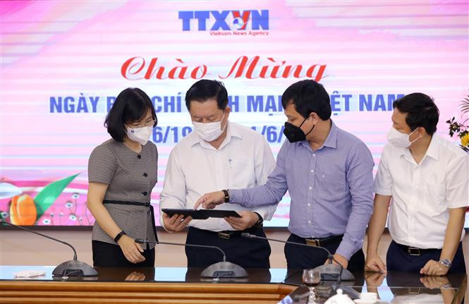 Phó Tổng Giám đốc TTXVN Vũ Việt Trang giới thiệu các ấn phẩm điện tử của TTXVN với Trưởng Ban Tuyên giáo Trung ương Nguyễn Trọng Nghĩa. Ảnh: Nguyễn Điệp - TTXVN Trưởng ban Tuyên giáo Trung ương Nguyễn Trọng Nghĩa chúc mừng TTXVN nhân Ngày Báo chí Cách mạng Việt Nam ảnh 3