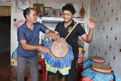 Nghệ nhân Thạch Tung truyền dạy cách đánh trống Chhay Dăm cho em Thạch Sen, con út trong gia đình