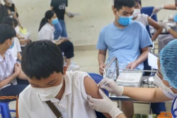 Nhân viên y tế phường Minh Khai (Hà Nội) tiêm mũi nhắc lại cho các em học sinh trường THCS Hà Huy Tập. Ảnh: Tuấn Đức - TTXVN
