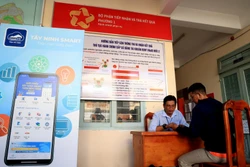Cán bộ UBND Phường 1 (thành phố Tây Ninh, tỉnh Tây Ninh) hướng dẫn người dân sử dụng tài khoản dịch vụ công quốc gia. Ảnh: Hồng Đạt - TTXVN
