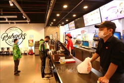Các cửa hàng ăn, uống trong TTTM BigC Thăng Long yêu cầu khách hàng đứng giãn cách và chỉ bán hàng mang về. Ảnh: Hoàng Hiếu – TTXVN