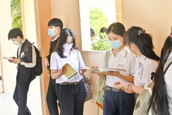 Các em học sinh tranh thủ ôn tập trước khi bước vào phòng thi. Ảnh: Hồng Hiếu- TTXVN