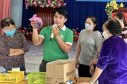 Hướng dẫn cách phân loại rác tại nguồn cho đại biểu tham dự chương trình. Ảnh: Hồng Giang - TTXVN