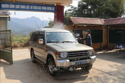 Tiến hành phun khử trùng, sát khuẩn tất cả các loại phương tiện vào khu cách ly tại huyện Mường Ảng (Điện Biên). Ảnh: Xuân Tiến-TTXVN