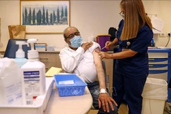 Nhân viên y tế tiêm vaccine phòng COVID-19 của hãng Pfizer-BioNTech cho người dân tại Tel Aviv, Israel, ngày 12/7/2021. Ảnh: AFP/ TTXVN